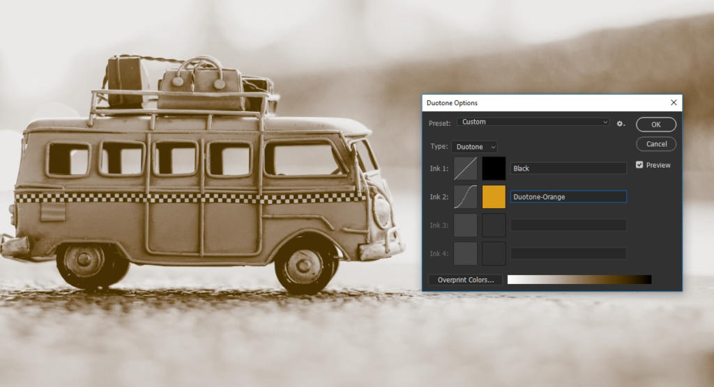 Et sepia-tonet billede af en legetøjsvogn med bagage på toppen, med Photoshop-duotone-indstillingsvinduet og valg i sort og sepia-orange.